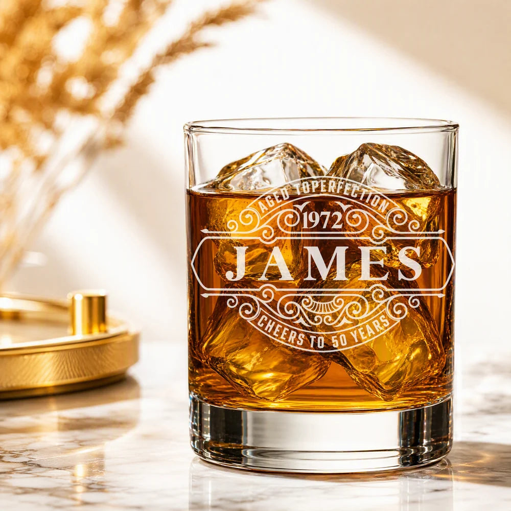 Short Aged to Perfection whiskey glass engraved with a name and year on a bar counter