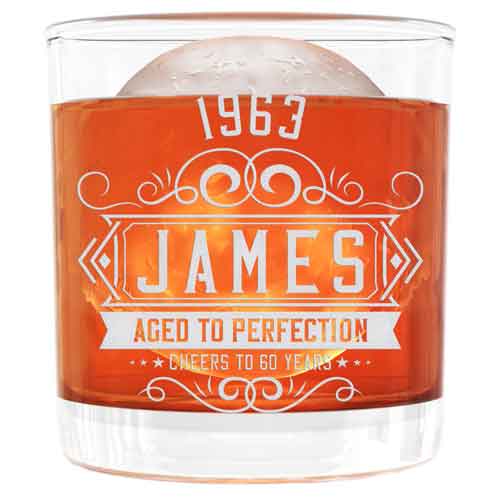 Short 10.5 oz Aged to Perfection whiskey glass engraved with James and 1963, shown with whiskey and ice
